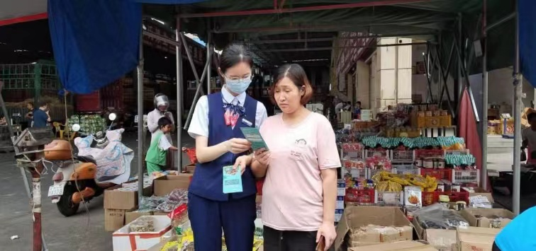 交通银行江西省分行客户经理为农贸市场商户介绍产品